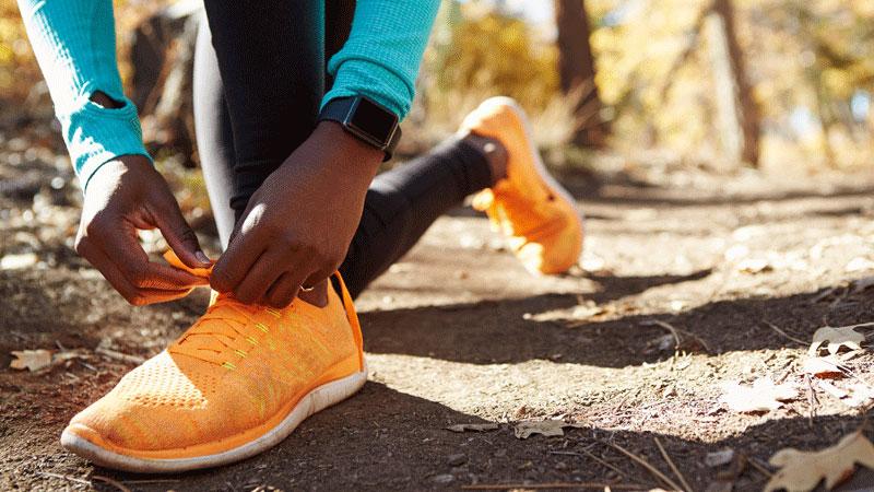 非裔美国女跑步者系着运动鞋