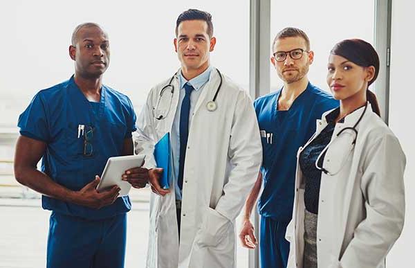 one female doctor, one male doctor, and two male medical workers posing for camera